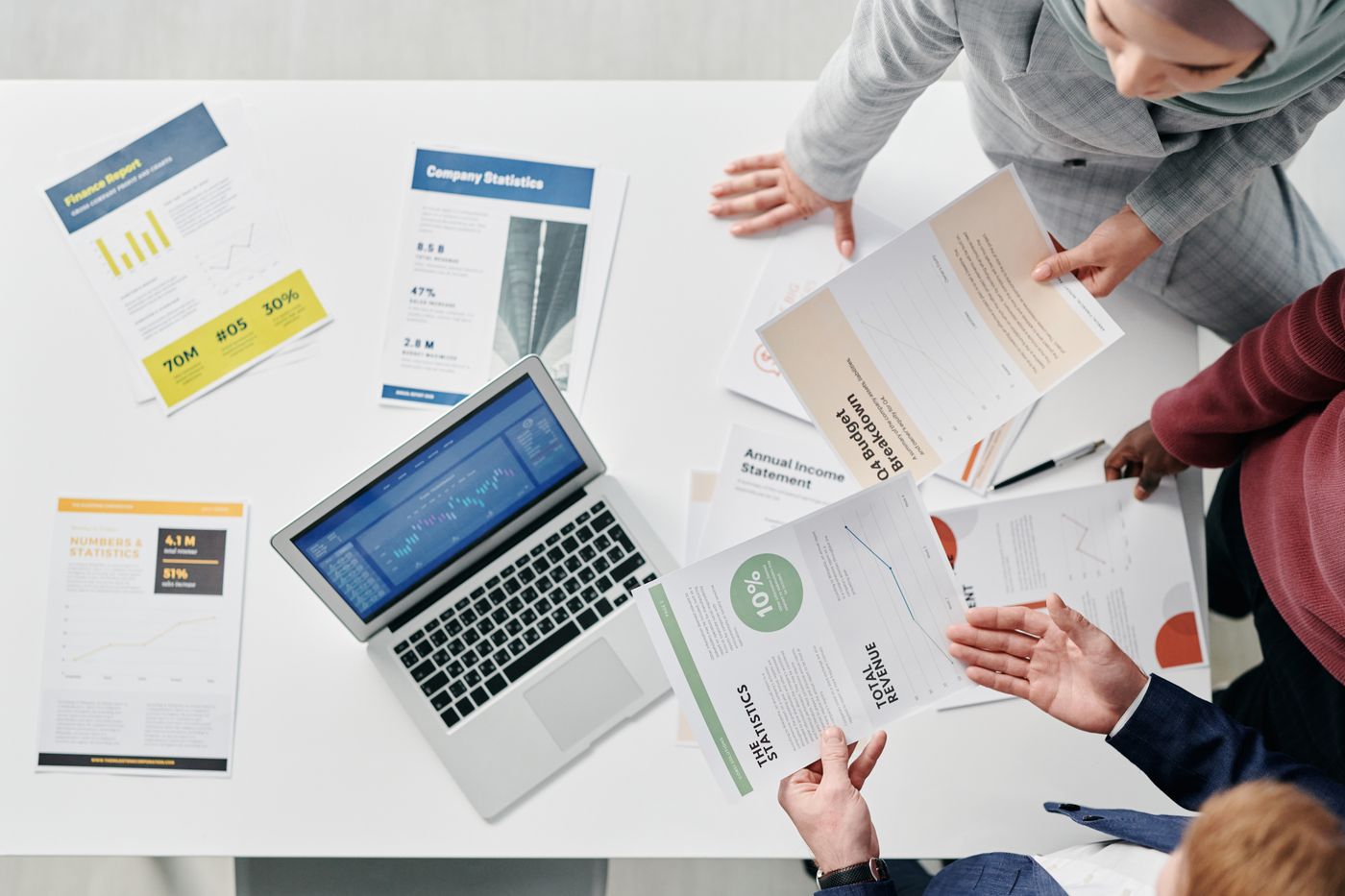 Colleagues reviewing reports and documents at a meeting table
